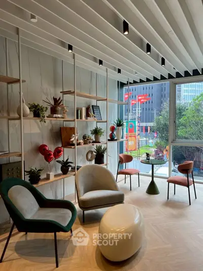 Modern living room with stylish furniture and large window offering city view