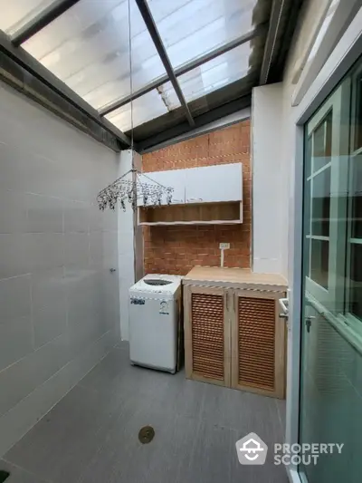 Charming laundry area with washing machine and rustic brick wall in modern home