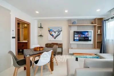 Modern living room with stylish decor, wall-mounted TV, and contemporary furniture in a bright, open space.