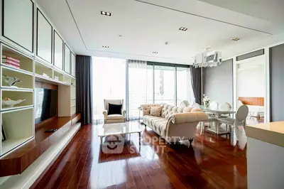 Luxurious living room with elegant decor and hardwood floors, featuring a plush sofa and large windows.