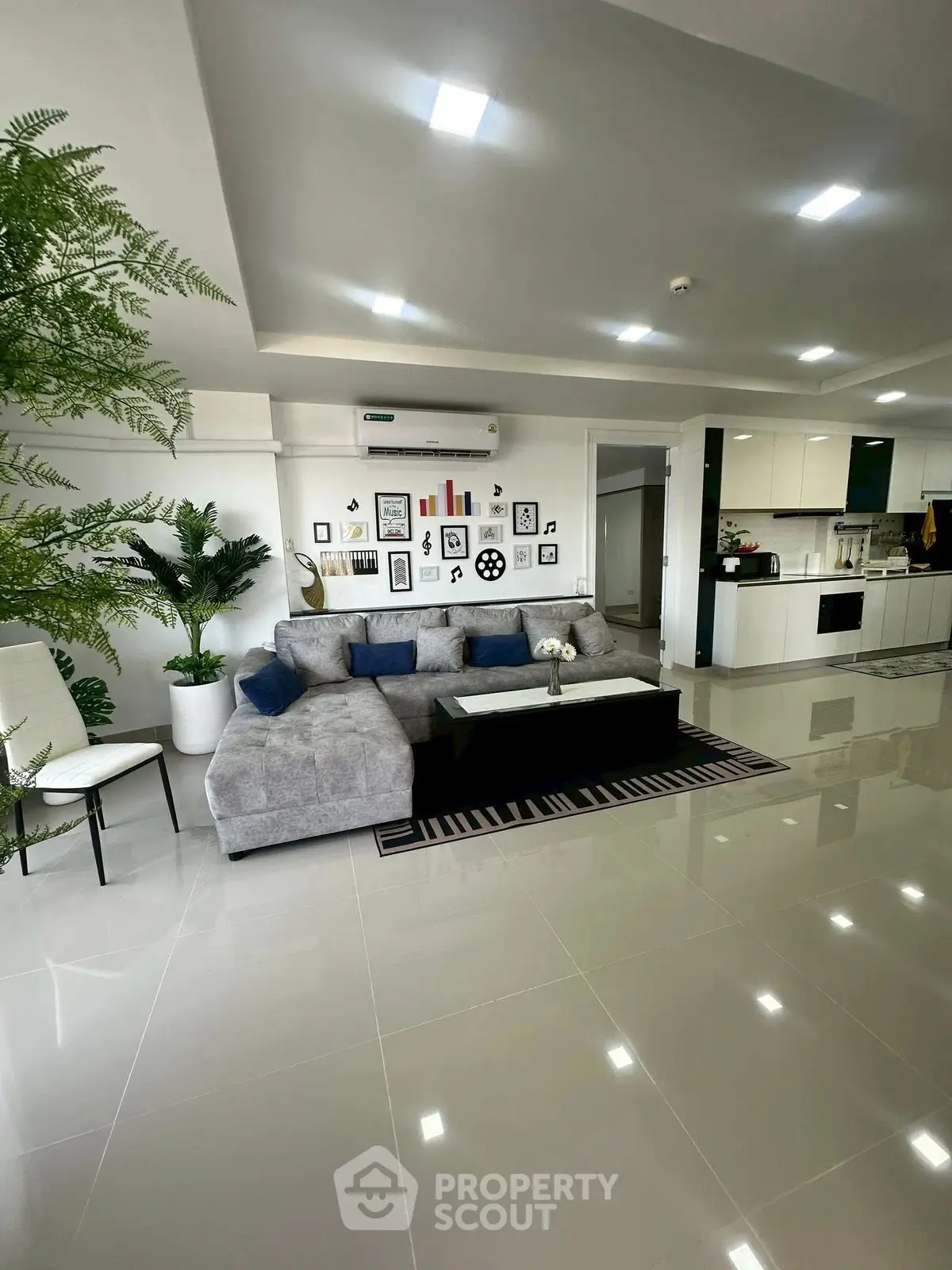 Spacious modern living room with sleek design and open kitchen layout.