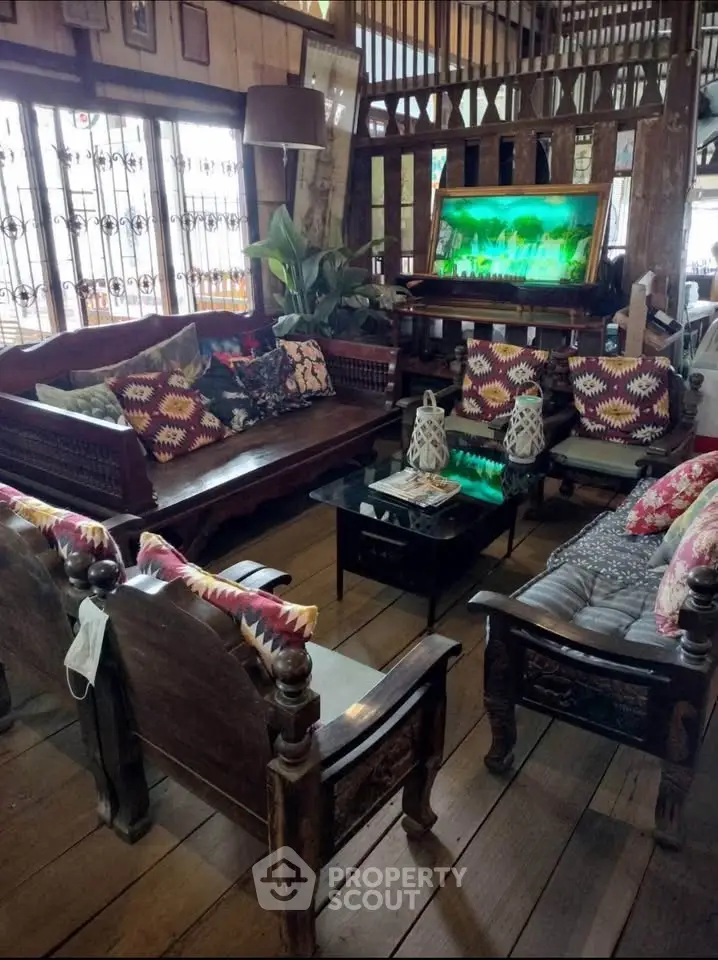 Charming rustic living room with wooden furniture and vibrant decor accents.