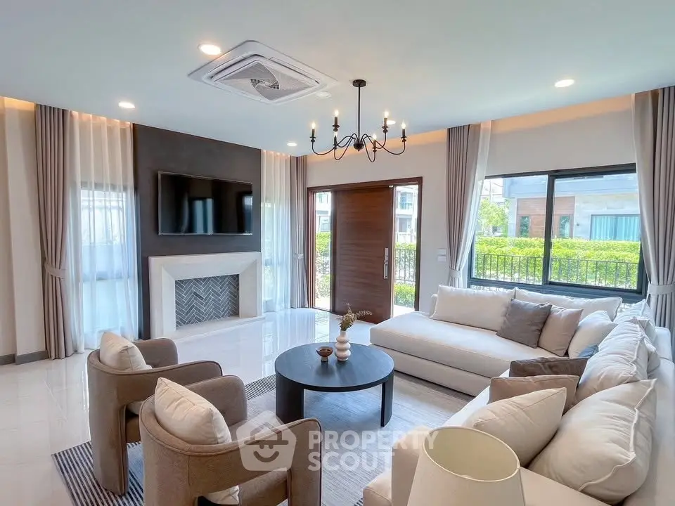 Luxurious living room with elegant decor, large windows, and modern chandelier in a spacious home.