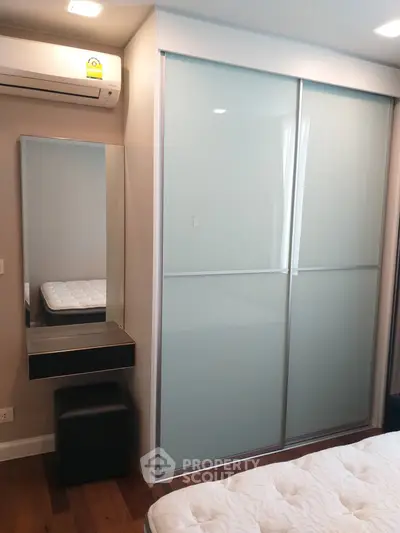 Modern bedroom with sliding closet doors and air conditioning unit