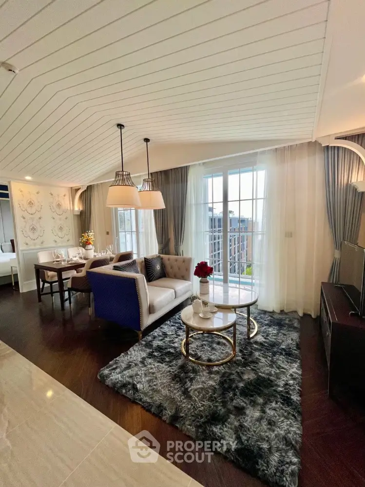 Luxurious open living room with elegant decor and city view, featuring plush seating and stylish lighting.