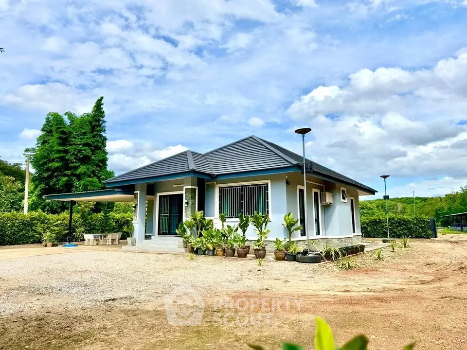 Charming single-story home with lush garden and modern design under a bright blue sky.