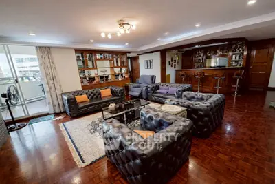 Luxurious living room with elegant leather sofas and a stylish bar area, perfect for entertaining guests.