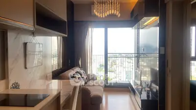 Modern living room with elegant chandelier and city view from large window.
