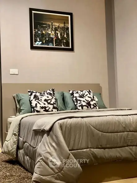 Cozy bedroom with stylish decor and cityscape artwork above bed