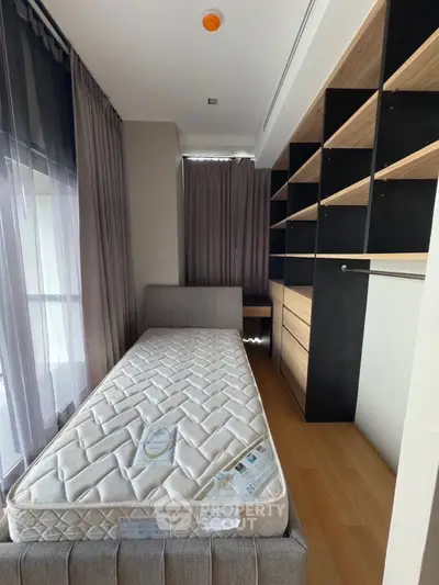 Modern bedroom with single bed and built-in storage, featuring floor-to-ceiling windows and elegant curtains.