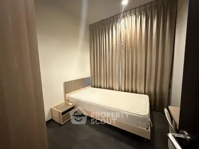 Modern minimalist bedroom with sleek design, featuring a single bed, elegant drapery, and warm ambient lighting, ideal for urban living.