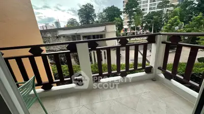 Charming balcony with wooden railing and city view, perfect for relaxation.