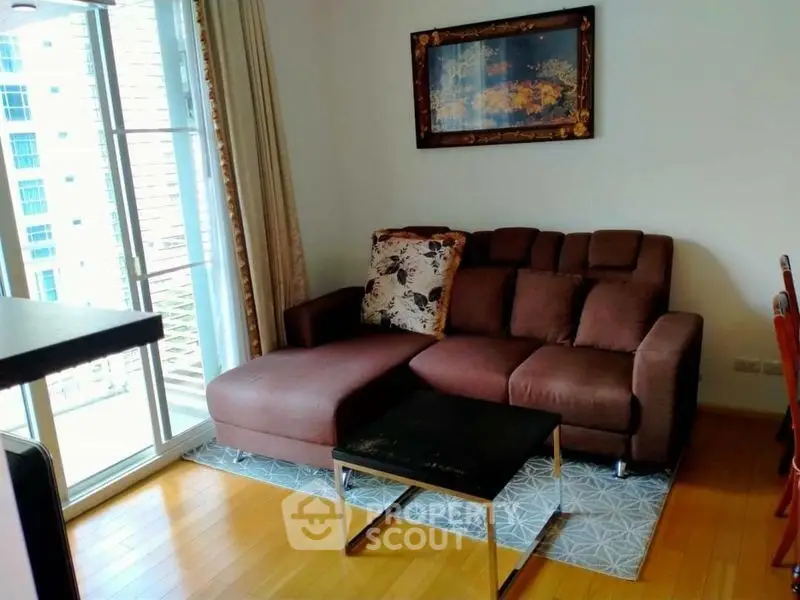 Cozy living room with brown sectional sofa and modern decor near balcony.