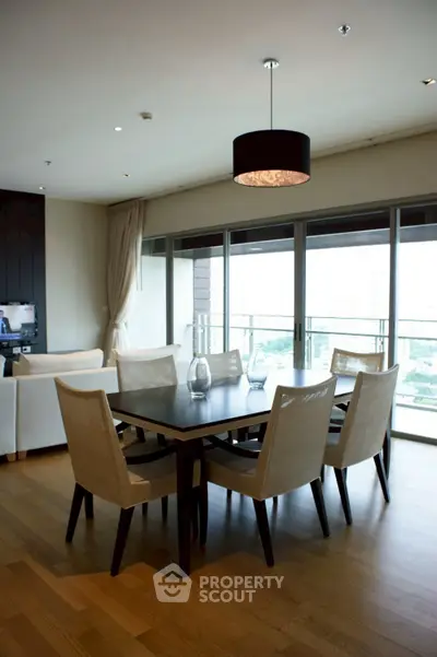 Spacious dining area with elegant furniture and large windows offering a stunning view.