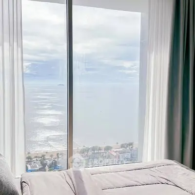 Luxurious bedroom with stunning ocean view through large window, perfect for serene living.