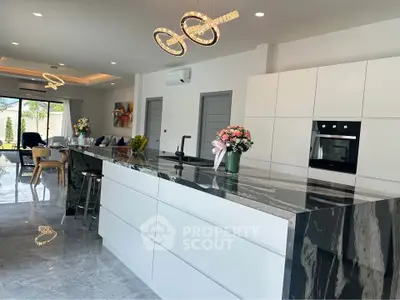 Luxurious modern kitchen with sleek marble island and open layout in a stylish home.