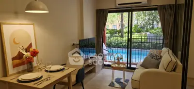 Charming living room with pool view, modern decor, and cozy dining area in stylish apartment.