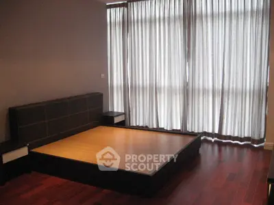 Spacious bedroom with modern design and large window for natural light.