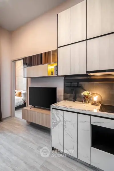 Modern kitchen with sleek cabinetry and marble countertops in a stylish apartment.