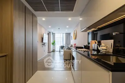 Modern open-layout kitchen and living room with sleek design and ample natural light.
