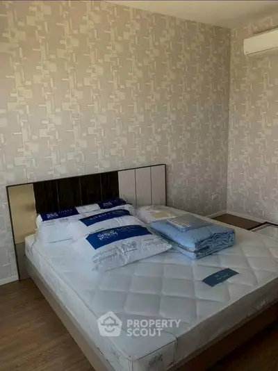 Modern bedroom with stylish wallpaper and air conditioning unit, featuring a neatly made bed.