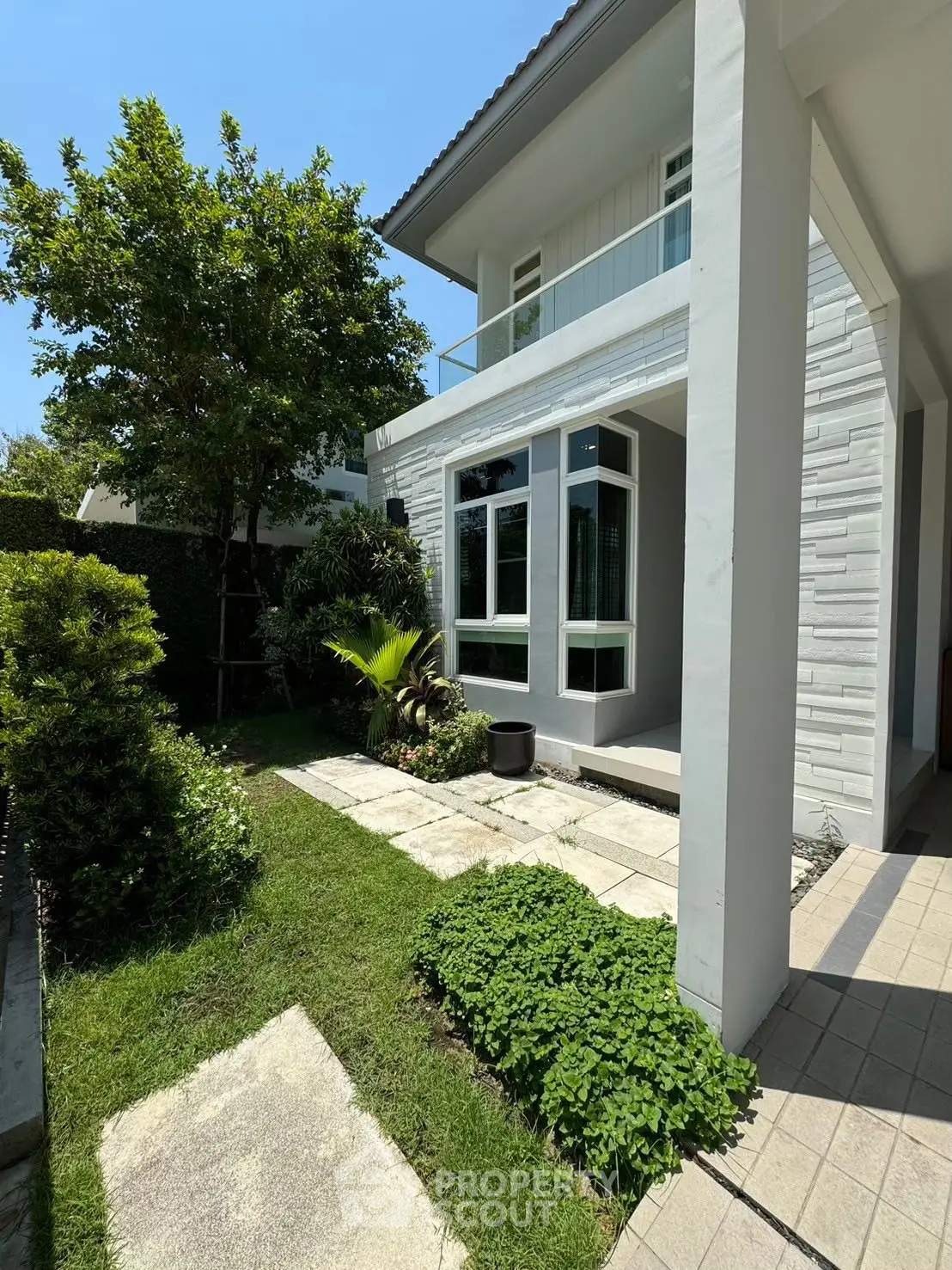 Charming two-story house with lush garden and modern exterior design