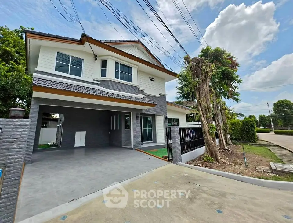 Stunning two-story modern house with spacious driveway and lush greenery, perfect for family living.