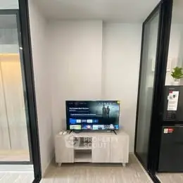 Modern living room with sleek TV setup and glass partitions