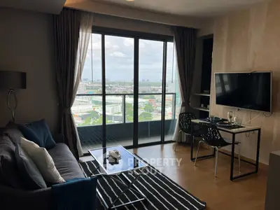 Modern living room with balcony and city view, featuring sleek furniture and stylish decor.