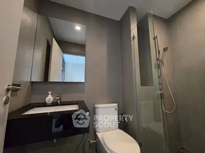 Modern bathroom with sleek design, featuring a glass shower and contemporary fixtures.