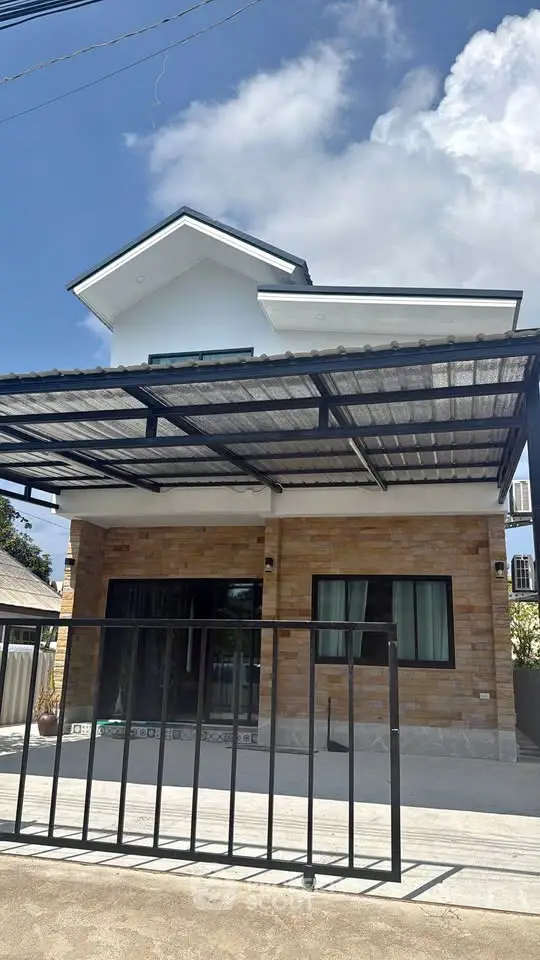 Modern two-story house with a sleek metal carport and brick facade under a clear blue sky.