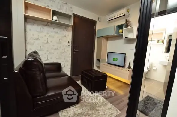 Modern living room with stylish decor and compact design, featuring a cozy leather sofa and wall-mounted TV.