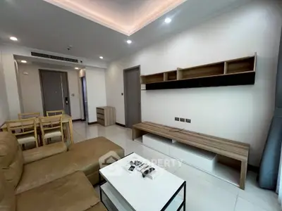 Modern living room with stylish furniture and open dining area in a contemporary apartment.