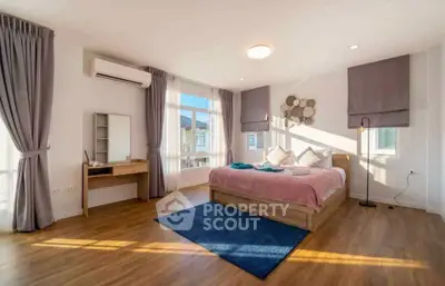 Spacious and bright bedroom with modern decor and large windows