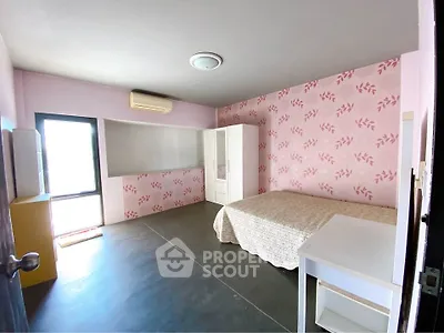 Spacious bedroom with pink floral wallpaper and modern furnishings