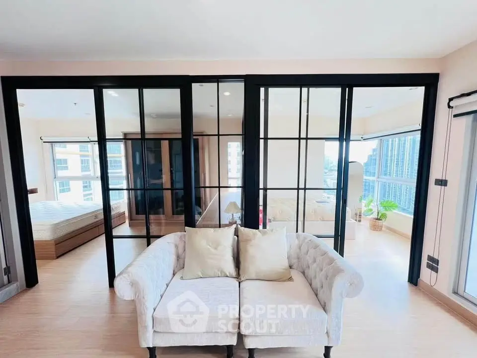 Spacious modern living room with elegant glass doors and cozy sofa, offering a bright and airy ambiance.