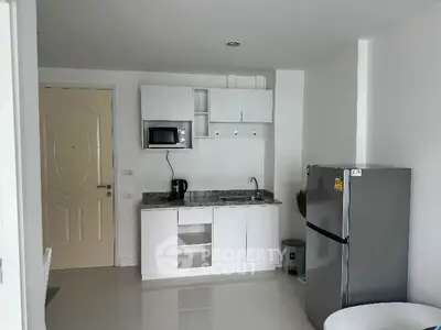 Modern compact kitchen with sleek white cabinets and stainless steel appliances