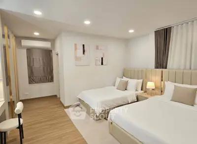 Modern bedroom with two beds, elegant decor, and ambient lighting