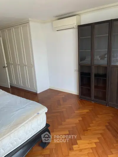 Spacious bedroom with elegant parquet flooring and ample closet space.