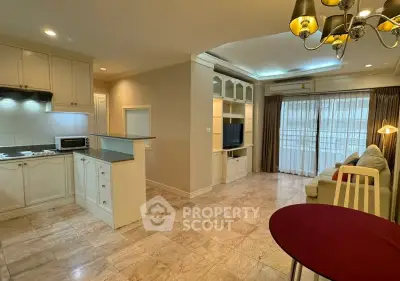 Spacious open-plan living room with modern kitchen and elegant lighting in a stylish apartment.