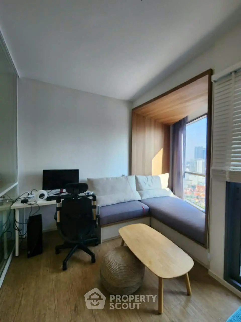 Cozy study nook with city view, featuring a modern desk, comfortable seating, and natural light.