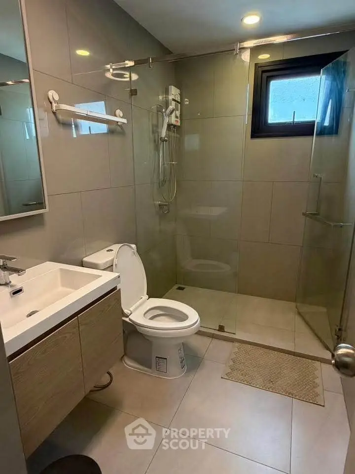 Modern bathroom with glass shower and sleek fixtures in a contemporary home.