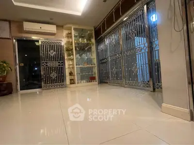 Spacious modern living area with sleek metal gates and polished tile flooring.