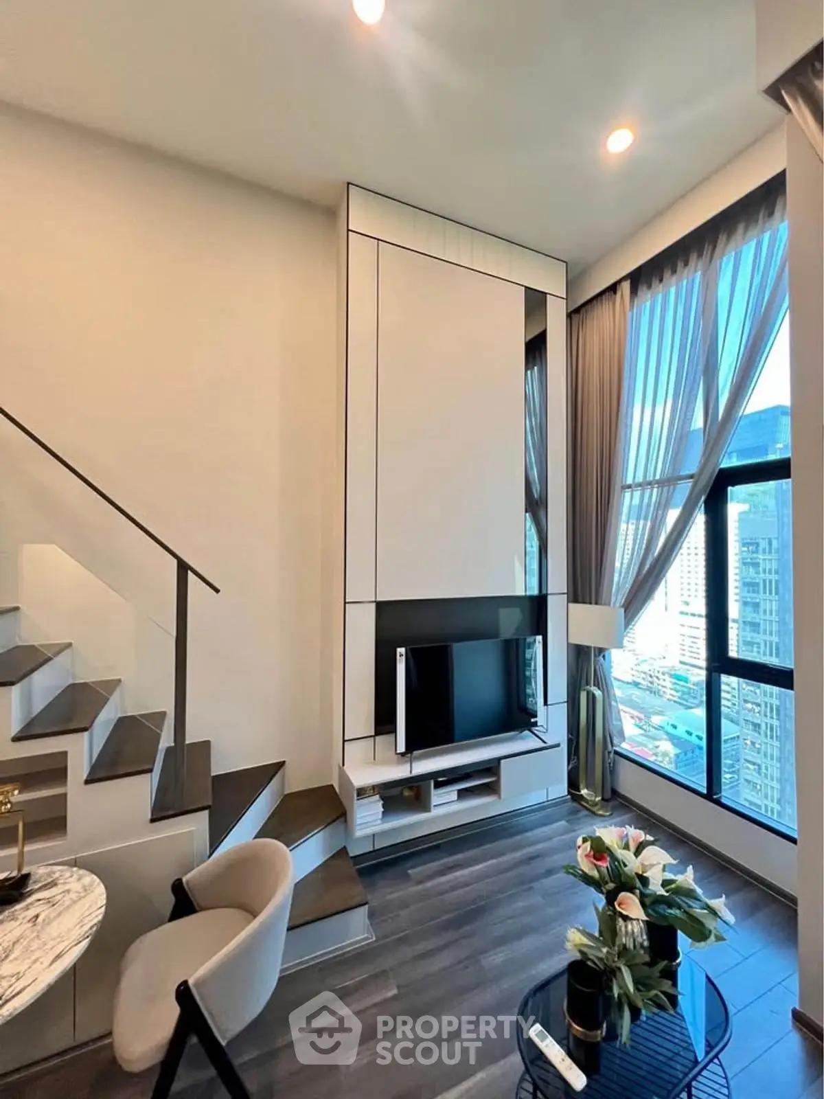 Modern duplex living room with large windows and stylish decor