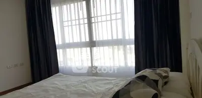 Cozy bedroom with large window and elegant curtains, perfect for natural light lovers.