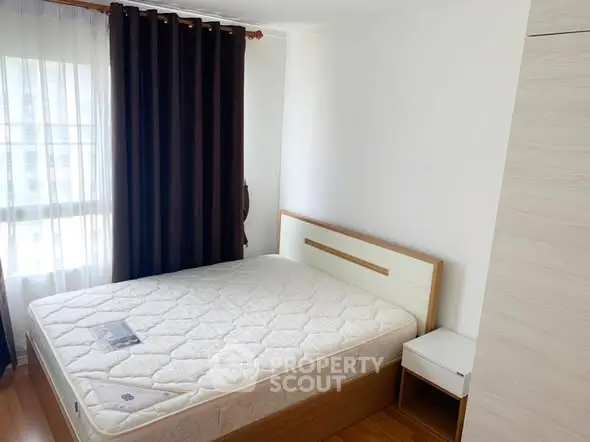 Cozy bedroom with natural light and modern furnishings, perfect for relaxation.