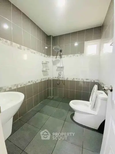 Modern bathroom with sleek tiles and contemporary fixtures in a stylish real estate property.