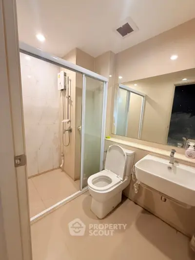 Modern bathroom with glass shower enclosure and sleek fixtures