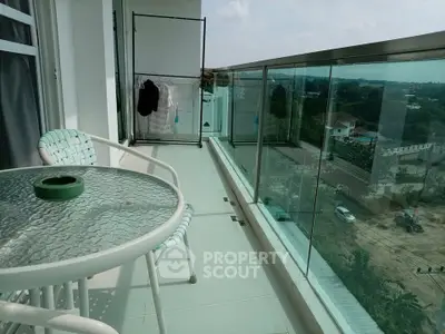 Spacious balcony with glass railing and outdoor seating offering scenic views.