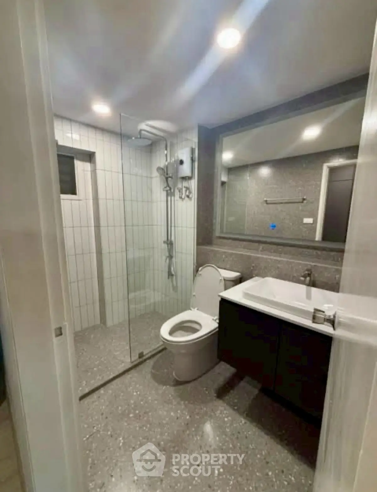 Modern bathroom with glass shower and sleek fixtures in a contemporary home.